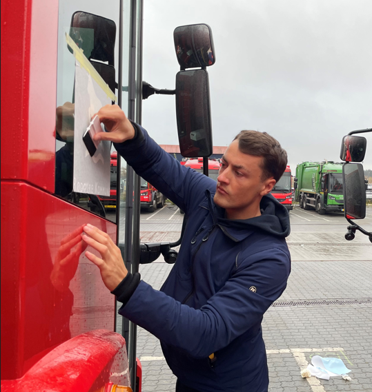 Montør der sætter skilt og folie op på en facade