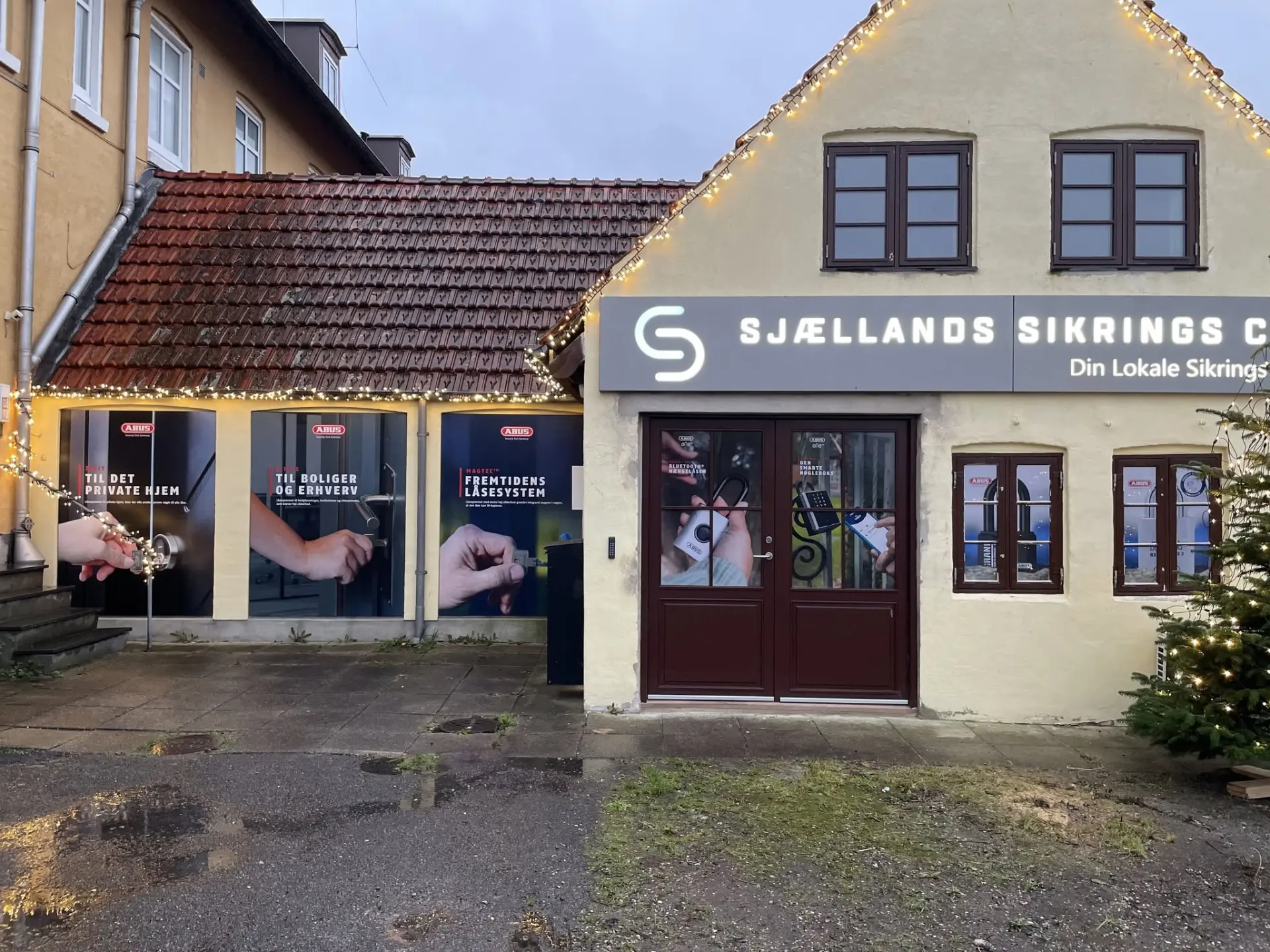 Montør der lægger folie på et stort glasparti med spartel