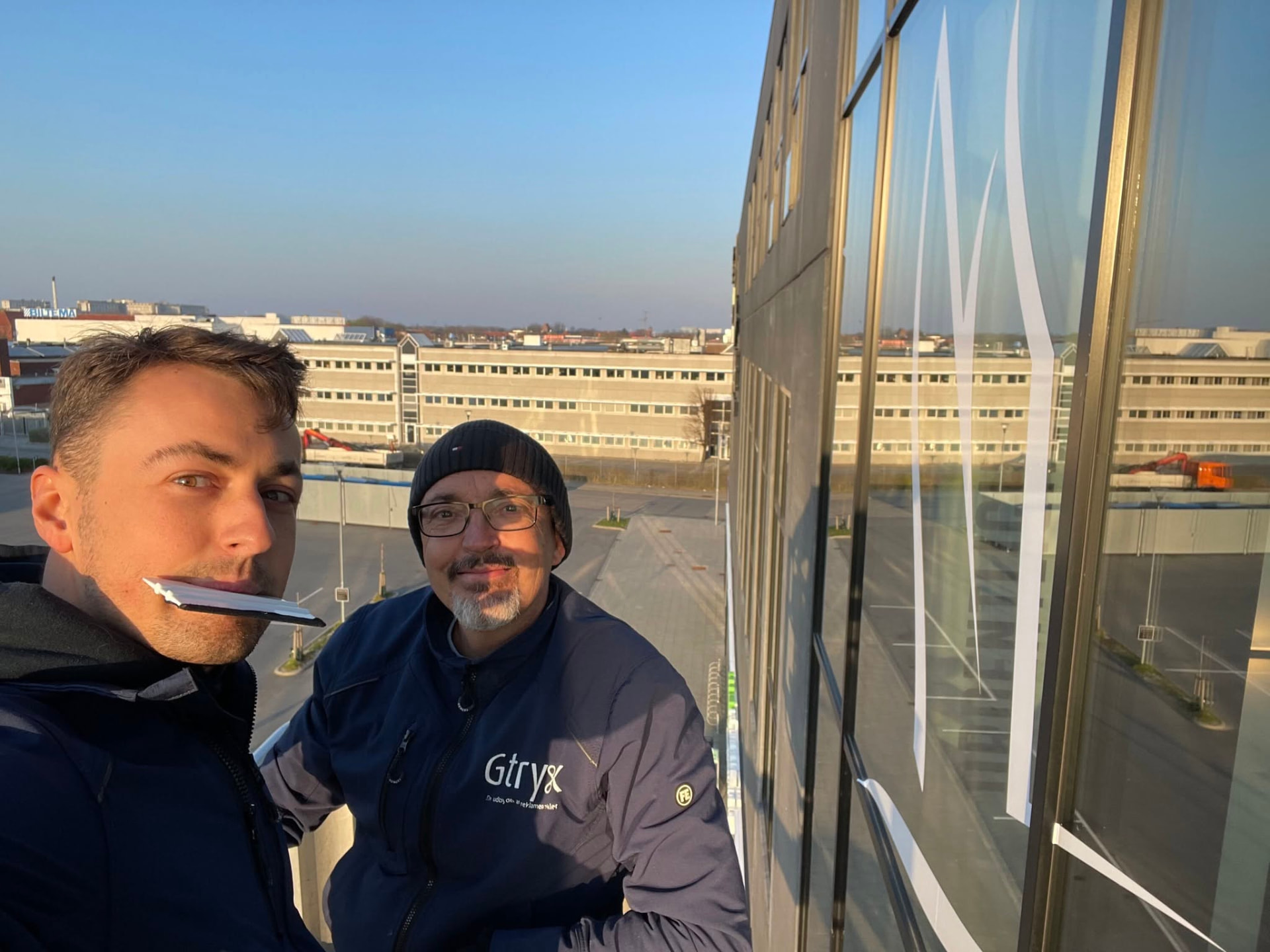 Gtryk-montører sætter folie på glasfacade